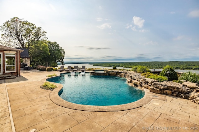 view of pool featuring a patio, a water view, and an in ground hot tub