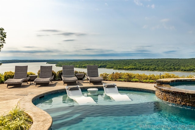 view of swimming pool with a patio, a water view, and an in ground hot tub