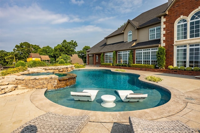 view of swimming pool featuring a patio and an in ground hot tub