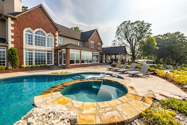 view of swimming pool featuring a patio and an in ground hot tub