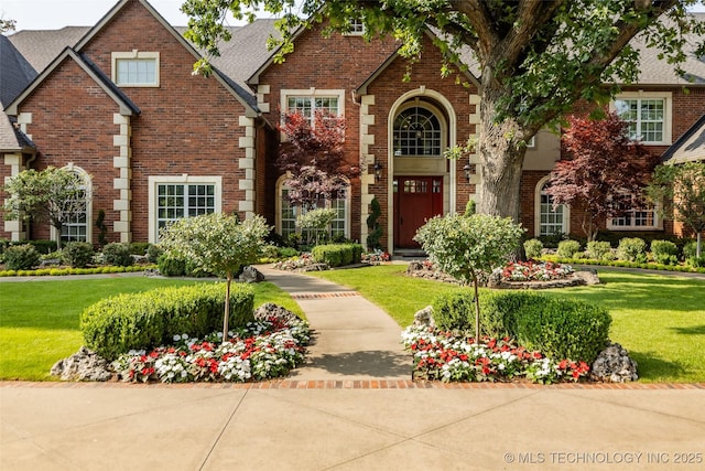 tudor home with a front lawn