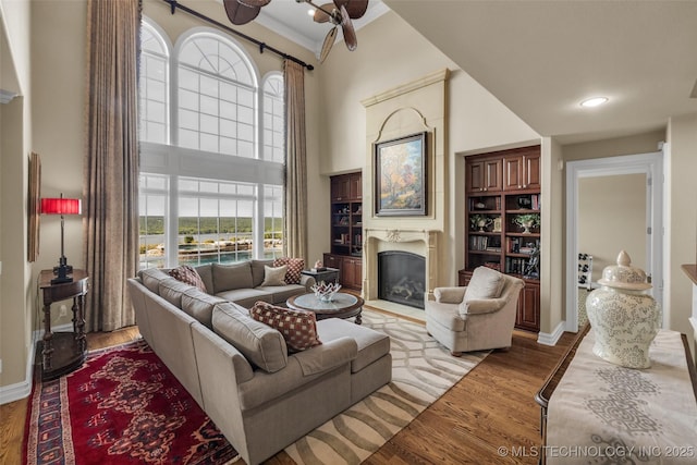 living room with a towering ceiling and light hardwood / wood-style flooring