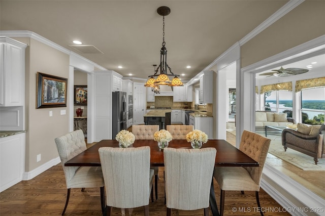 dining space featuring crown molding, dark hardwood / wood-style floors, and ceiling fan