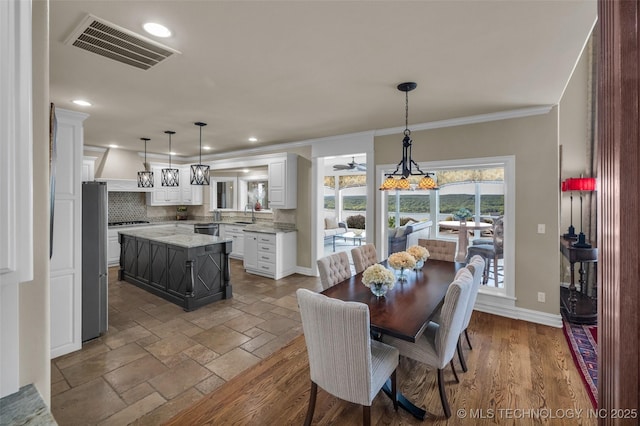 dining room featuring ornamental molding and sink