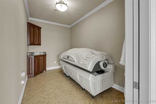 interior space with light tile patterned floors, crown molding, and cabinets