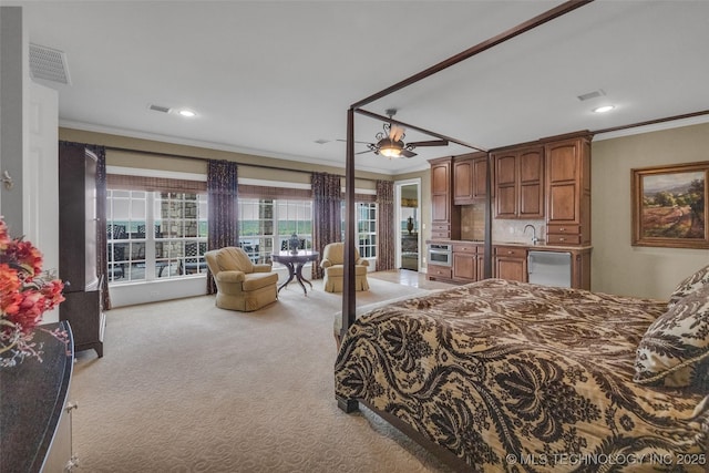 bedroom featuring ornamental molding, sink, and light carpet