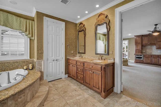 bathroom featuring backsplash, ornamental molding, vanity, ceiling fan, and tiled tub