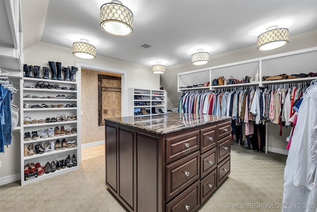 spacious closet featuring lofted ceiling and light colored carpet