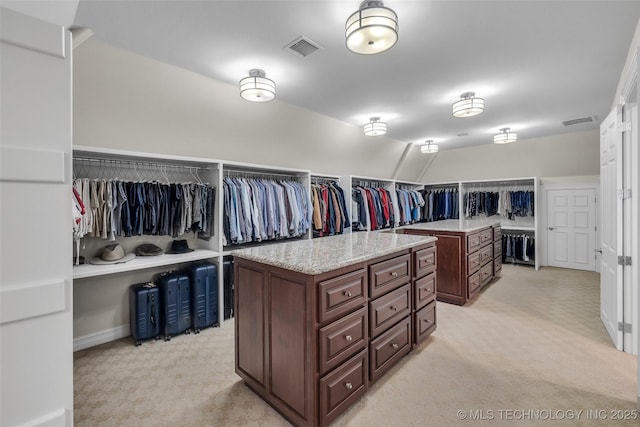 walk in closet featuring lofted ceiling and light colored carpet