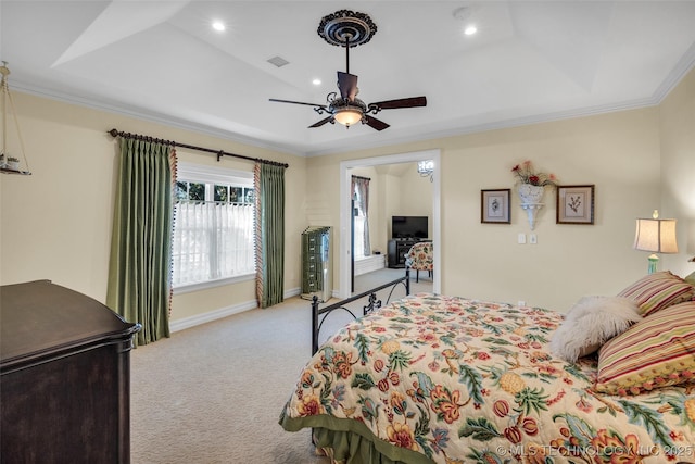 bedroom featuring ornamental molding, carpet floors, ceiling fan, and a tray ceiling