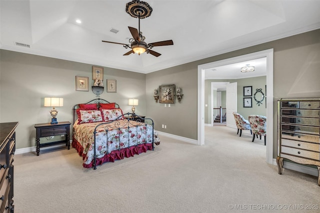 carpeted bedroom featuring a tray ceiling, ornamental molding, and ceiling fan