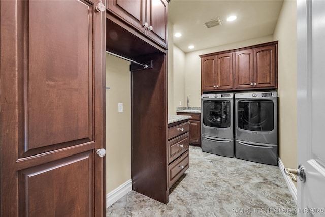 washroom featuring cabinets, washing machine and clothes dryer, and sink