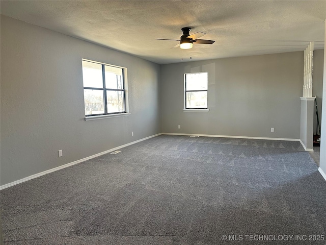 carpeted empty room featuring ceiling fan, a healthy amount of sunlight, and a textured ceiling