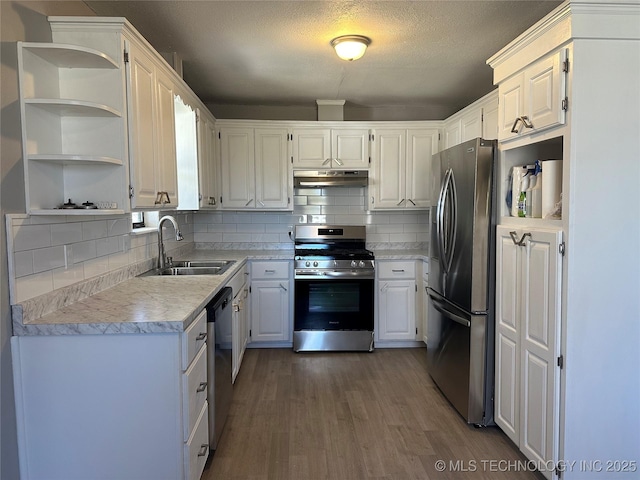 kitchen with sink, stainless steel appliances, hardwood / wood-style floors, decorative backsplash, and white cabinets