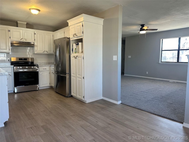 kitchen with stainless steel appliances, a textured ceiling, decorative backsplash, and white cabinets