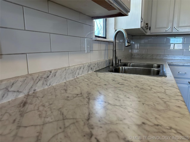 kitchen featuring white cabinetry, sink, and decorative backsplash