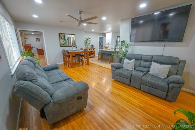 living room featuring ceiling fan and light hardwood / wood-style flooring