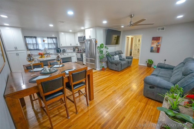 dining room with ceiling fan and light hardwood / wood-style floors