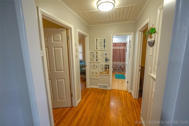 hallway with hardwood / wood-style floors and crown molding