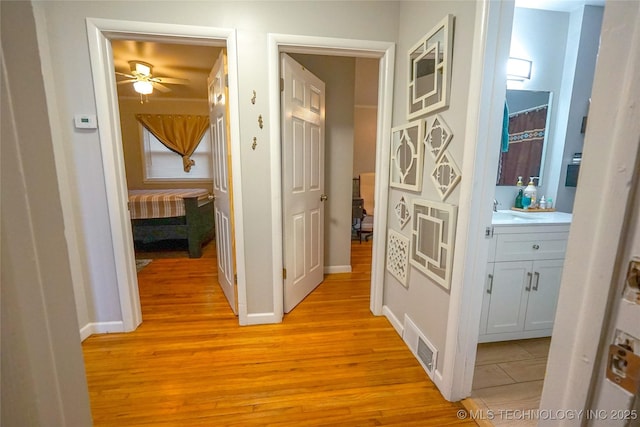 hall featuring sink and light hardwood / wood-style flooring