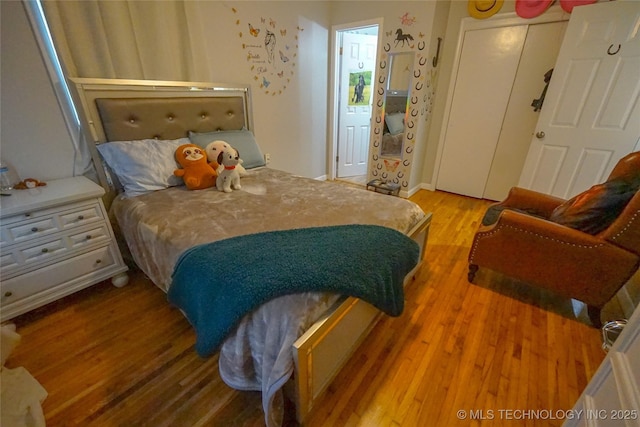 bedroom featuring hardwood / wood-style floors and a closet