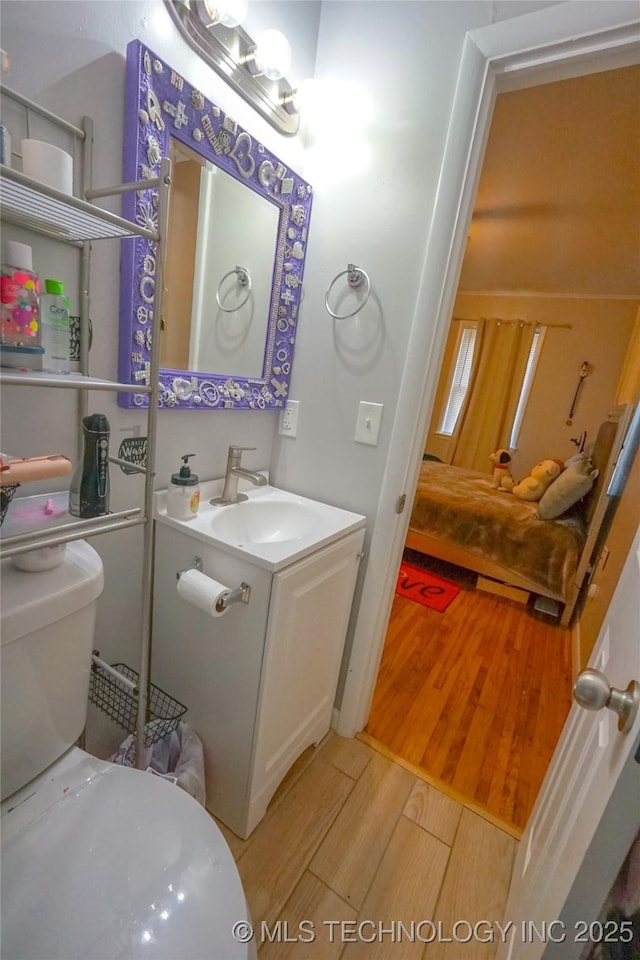 bathroom with hardwood / wood-style flooring, vanity, and toilet