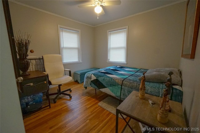 bedroom featuring wood-type flooring, ornamental molding, and ceiling fan