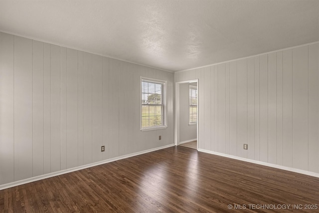 unfurnished room with crown molding and dark hardwood / wood-style flooring