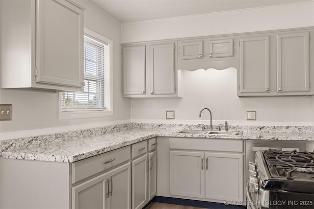 kitchen featuring sink, gas range, gray cabinets, and ornamental molding