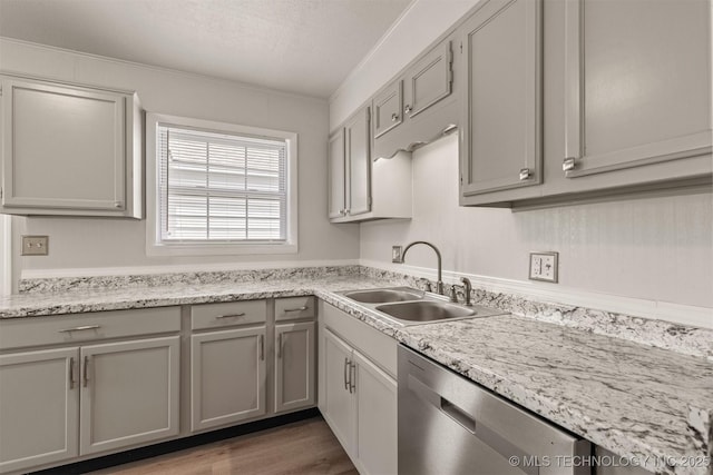 kitchen with sink, gray cabinetry, dark hardwood / wood-style floors, ornamental molding, and stainless steel dishwasher