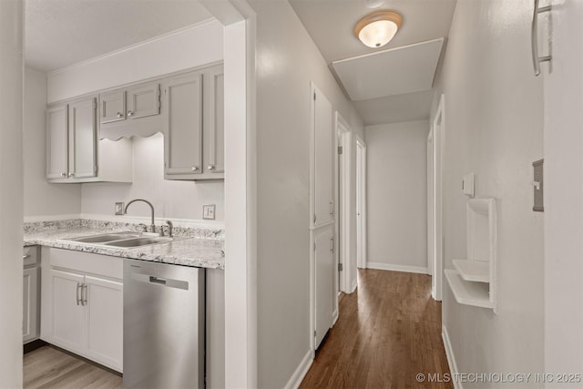 kitchen with dishwasher, sink, and light hardwood / wood-style flooring