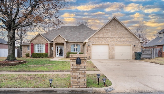 single story home with a garage and a yard