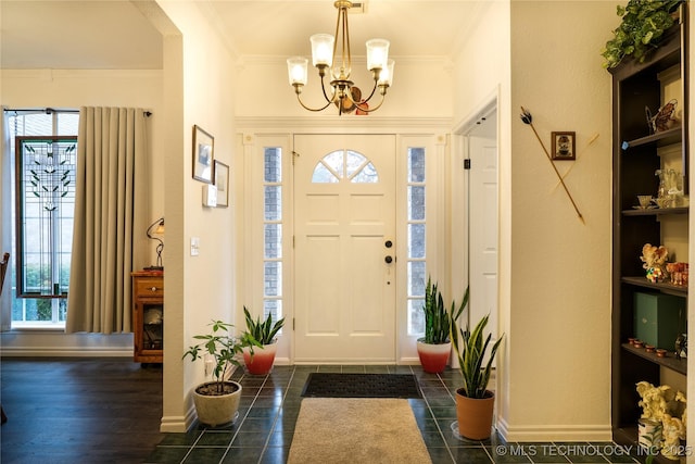 entrance foyer featuring ornamental molding and an inviting chandelier