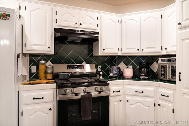 kitchen with white cabinetry, tile counters, and stainless steel range with gas stovetop