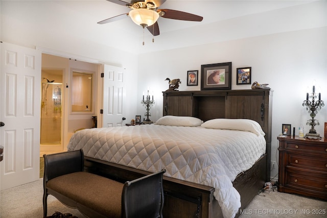 carpeted bedroom with ensuite bath and ceiling fan