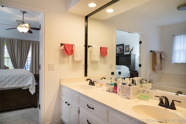 bathroom with vanity, a bathing tub, and ceiling fan