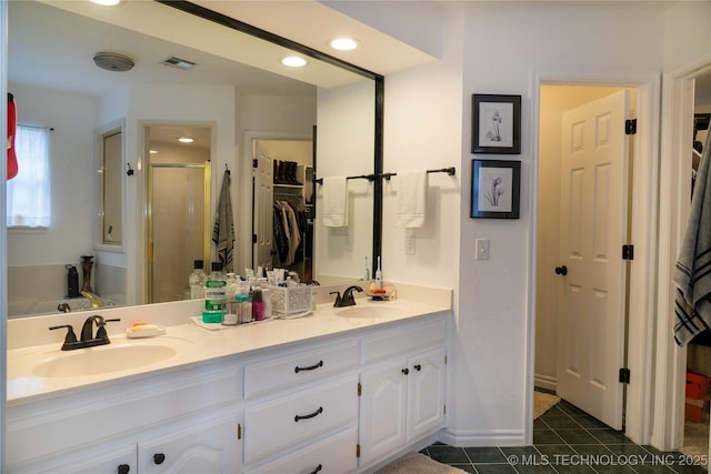 bathroom with a shower with door, vanity, and tile patterned floors