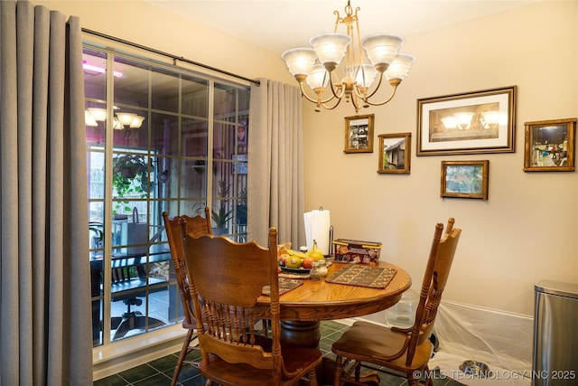 dining space with an inviting chandelier and dark tile patterned flooring