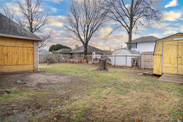 yard at dusk featuring a shed