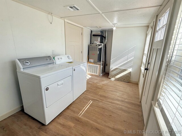 washroom with separate washer and dryer and light hardwood / wood-style flooring