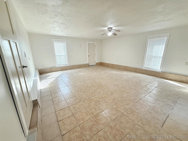 spare room with a textured ceiling and ceiling fan