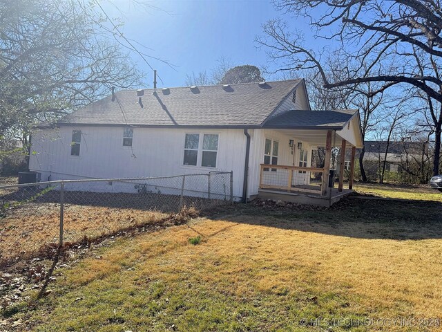 rear view of property featuring a yard and covered porch