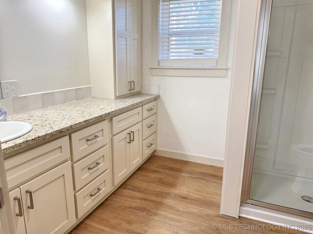 bathroom with vanity, hardwood / wood-style floors, and an enclosed shower