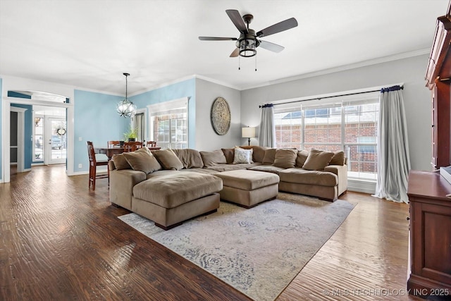 living room featuring crown molding, ceiling fan with notable chandelier, hardwood / wood-style floors, and french doors