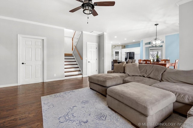 living room featuring hardwood / wood-style floors, crown molding, and ceiling fan with notable chandelier