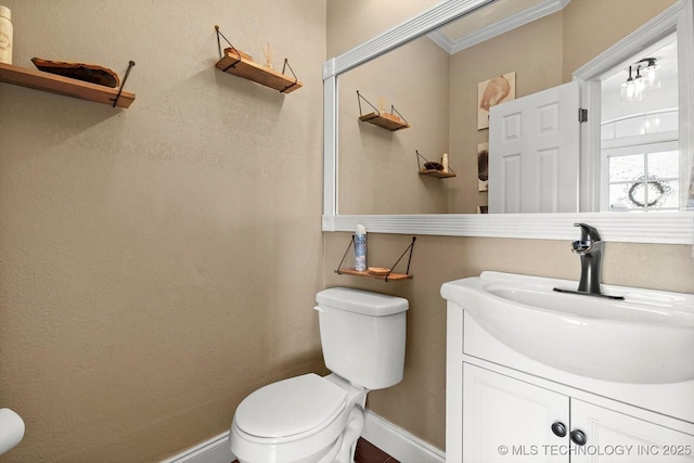 bathroom with vanity, ornamental molding, and toilet