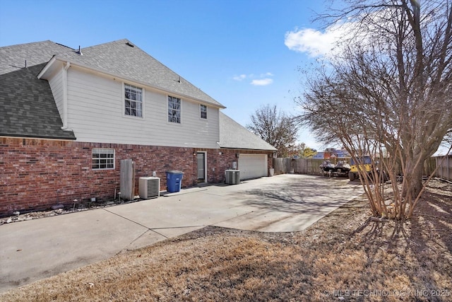 back of house featuring a garage and central AC