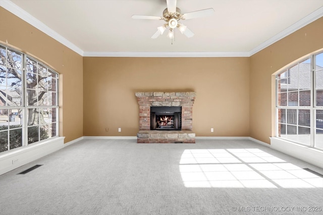 unfurnished living room with light carpet, a fireplace, ornamental molding, and ceiling fan