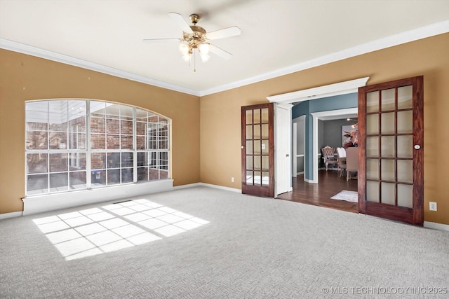 carpeted empty room featuring french doors, ceiling fan, and ornamental molding