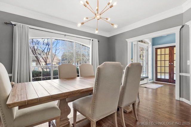 dining space featuring dark hardwood / wood-style flooring, ornamental molding, plenty of natural light, and a chandelier